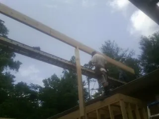 Carpenter setting a ridge beam over a new addition frame — Ice Dam Removal by Roofing Brothers in Tenmile