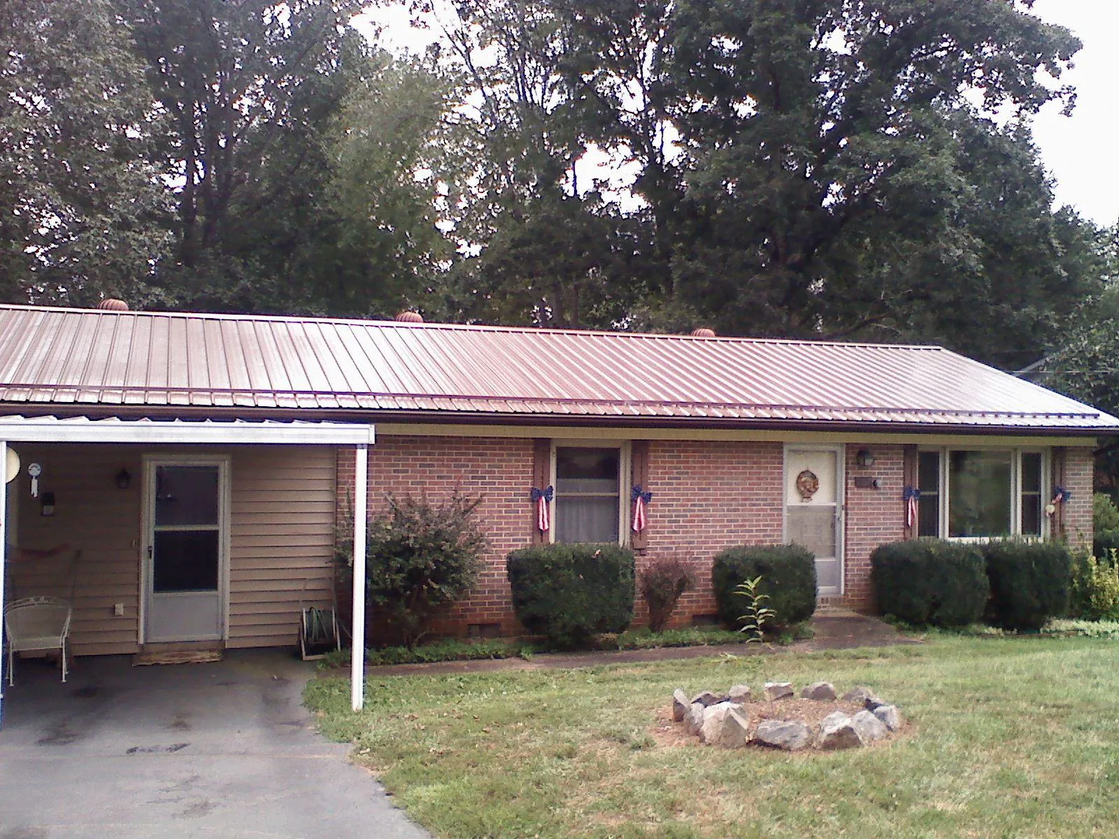 Bronze metal roof and carport on a brick ranch home — Roof Repair work by our crew in Tenmile