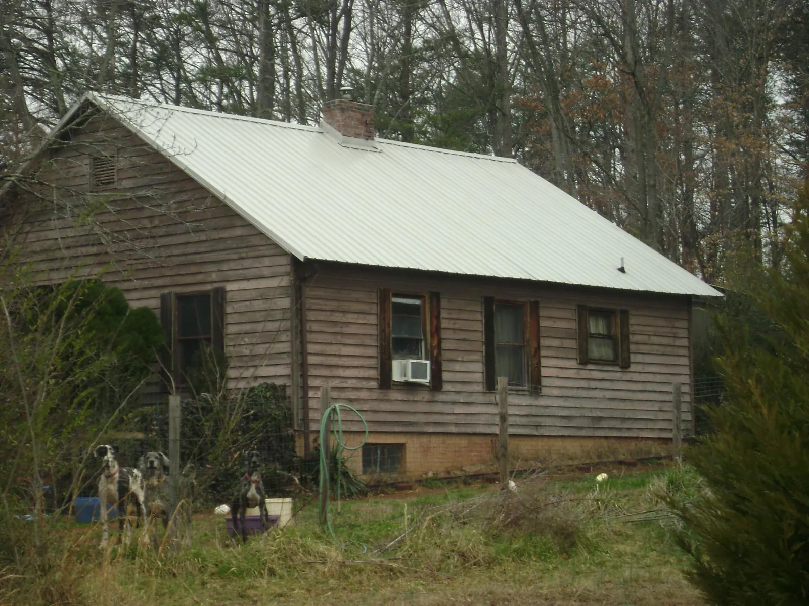 White metal roof on an old wood sided farmhouse, from a Metal Roof Installation job in Tenmile